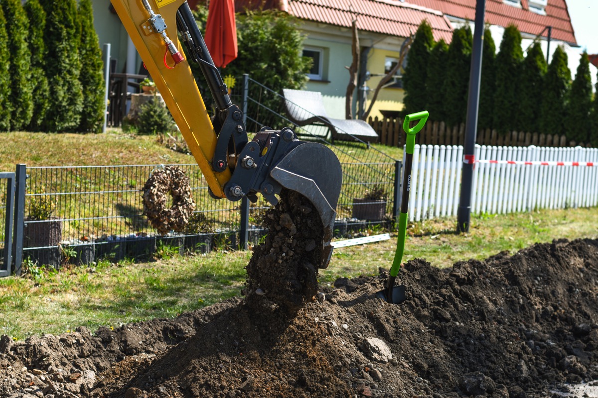 Bagger hebt die Baugrube für einen Pool aus