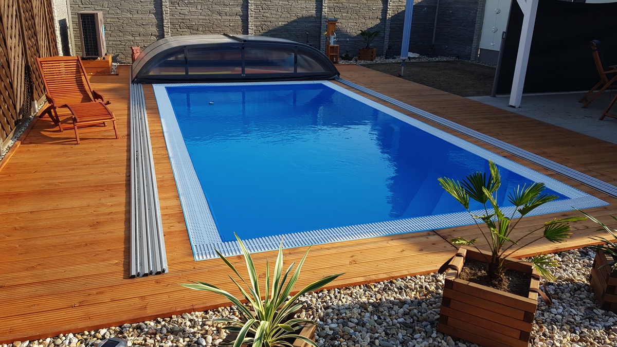Fertigbecken mit Holzterrasse und aufgeschobener Überdachung, gebaut von Swimmingpool 24